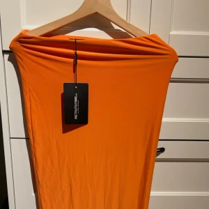 Orange långkjol PrettyLittleThing - Säljer denna snygga stretchiga långkjol från pretty little thing <3 helt ny, prislappen kvar! 