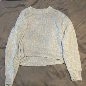 Ljusblå stickad tröja från H&M - Mysig ljusblå stickad tröja från H&M i storlek XS. Perfekt för kyliga dagar med sin mjuka och bekväma passform. Tröjan har långa ärmar och ribbade kanter vid hals, ärmslut och nederkant. Passar både till vardags och mysiga hemmakvällar.