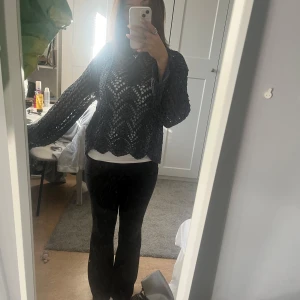 Mörkblå stickad tröja - Säljer en superfin mörkblå stickad tröja med ett snyggt hålmönster. Den har långa ärmar och en lös passform som är perfekt för både höst och vår. Tröjan är i mycket bra skick och passar perfekt för en avslappnad stil. Perfekt att ha över en enkel topp för en lager-på-lager-look!