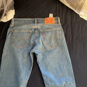 Levis 511 jeans - Snygga Levis 511 jeans i klassisk blå denim. De har en normal passform med dragkedja och knapp framtill. Perfekta för en stilren look.