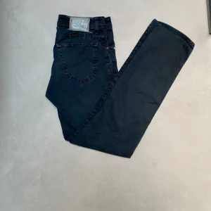 Svarta Jacob Cohën jeans 622 - Säljer nu riktigt feta svarta jeans från Jacob Cohën, modell Type 622.C.🙌Dem är slim fit. Det finns inga tecken av användning förutom att baklappen har krympt lite i tvätten. Men annars är jeansen i bra skick. Dem är slim fit och storlek 31 i midjan vilket motsvarar 41cm tvärs över och 104cm från midjan och ner. Tveka inte på att höra av er vid frågor och funderingar.