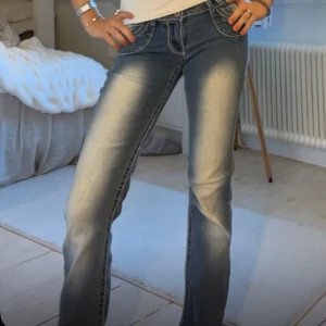 Blå bootcut jeans - Snygga och så coola blå bootcut jeans med ljusa slitningar och dekorativa sömmar. 
