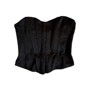 Svart korsett - Snygg svart korsett i satinmaterial med en elegant och stilren design. Tajt i storleken. Perfekt för en utgång eller till vardagen!
