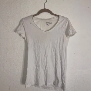Vit t-shirt från Basic You - Säljer en enkel och stilren vit t-shirt från Basic. Den har en v-ringad hals och korta ärmar, perfekt för en avslappnad look. Passar bra till jeans eller shorts. Perfekt basplagg i garderoben!