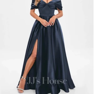Marinblå balklänning från JJ's House - Elegant marinblå aftonklänning i satin från JJ's House. Klänningen har en offshoulder-design med en v-ringad överdel och en hög slits. Perfekt för en glamourös kväll eller en bal! Använd vid ett tillfälle och kostade ca 2200kr inklusive frakt. 