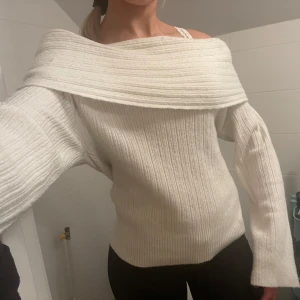 Vit tröja från Nelly  - Säljer en stickad tröja med offshoulder-design. Den är ifrån Nelly i storlek XS men passar mig som är 172 cm lång och bär storlek S. 