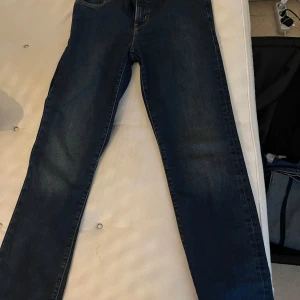 Levi's Premium jeans - Snygga Levi's Premium jeans i en klassisk blå färg. De har en straight passform och är högmidjade, vilket ger en tidlös look. Perfekta för en avslappnad stil med sina fem fickor och slitstarka denimkvalitet.