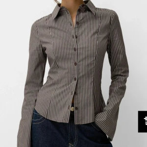 Oanvänd randig blus från Bershka  - Snygg mörkbrunrandig figursydd blus från Bershka köpt på Zalando. Oanvänd och så fin men var för liten för mig och hann inte skicka tillbaka, lappar och allt kvar🥰