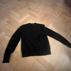 Svart tröja - Säljer en stilren svart tröja med långa ärmar. Perfekt för en minimalistisk look och passar till många olika outfits. Vet inte vilket material men känns cashmir liknande!