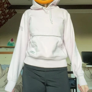 Ljusrosa hoodie  - Säljer en ljusrosa hoodie med stor ficka framtill och justerbar huva. Perfekt för en avslappnad stil. Den har långa ärmar och en bekväm passform.