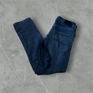 Gråa jeans från Jack & Jones - Snygga gråa jeans från Jack & Jones med klassisk femficksdesign. Perfekta för en avslappnad stil. De har en Slimstraight passform och är tillverkade i slitstarkt denim. Perfekt för dig som inte vill ha för tajta jeans. Skick:9/10 Pris diskuterbart.