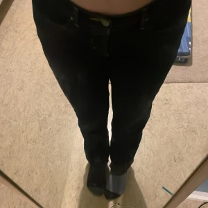 Levi's 312 Shaping Slim Jeans - Snygga Levi's 312 Shaping Slim jeans i mörkblå denim. De har en slim passform som framhäver figuren och klassiska femficksdetaljer. Perfekta för en stilren look.