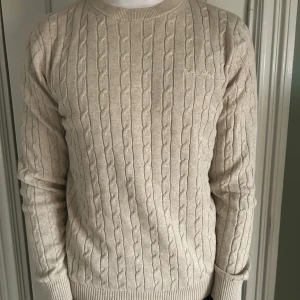 Stickad tröja från bonelid - Säljer en stilren beige kabelstickad tröja från bonelid i str S men passar även M personen på bilden är 180 cm och väger 70 kg. tveka inte på att kontakta mig vid minsta fundering !🙌