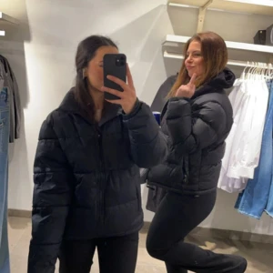 Svart pufferjacka från Everest - Säljer en svart pufferjacka från Everest. Jackan har en dragkedja framtill och är perfekt för kyligare väder. Den är långärmad och har en klassisk pufferdesign som ger både stil och värme. Den är max använd 4 gånger. Köpt förra året 