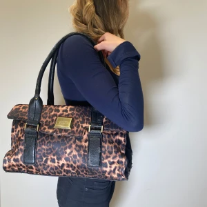 Leopard väska - En as cool leopard väska med gulddetaljer ifrån FIORELLI! 🐆 35x20cm Små defekter där färgerna försvunnit ifrån det svarta. 
