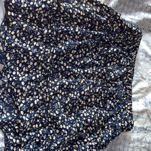 Blommig kjol från Shein - Söt blommig kjol från Shein i mörkblått med små vita och gula blommor. 