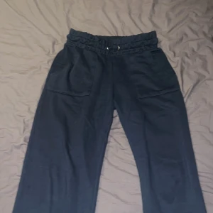 Säljer mörk blå mjukisbyxor dom dem passar it mig jättebra men lite använda men jätte bra byxor  - Säljer ett par svarta mjukisbyxor med resårmidja och snörning. Byxorna har en loose passform och praktiska fickor fram. Perfekta för en avslappnad stil.