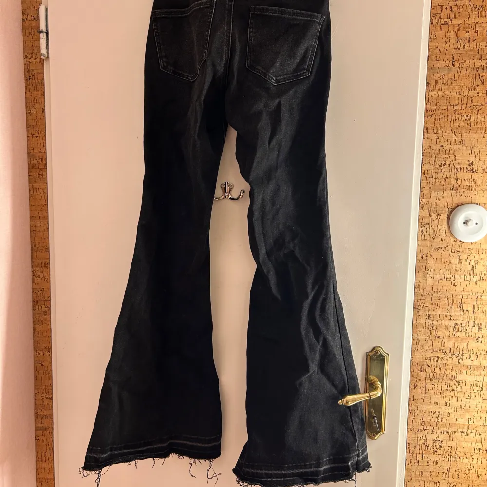 Snygga svarta bootcut jeans från Stradivarius i storlek 38. De har en klassisk femficksdesign och en knappgylf. Perfekta för en trendig look med sin utsvängda stil.. Farkut & Housut.