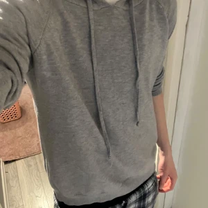 Grå kaschmir hoodie - Säljer en stilren grå hoodie med justerbar huva och långa ärmar. Perfekt för en avslappnad look. Den är mjuk och bekväm, idealisk för kyligare dagar.