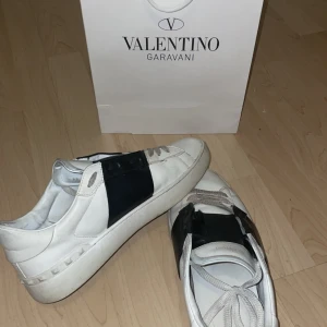 Valentino Garavani sneakers - Snygga vita Valentino Garavani sneakers med svarta detaljer. Skorna har snörning och en stilren design som passar perfekt för en trendig look. Priset är inte hugget i sten, hör av er för mer info. Storlek 44 men passar även 45. 