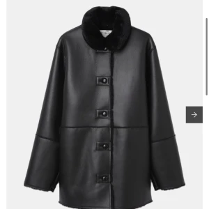 Svart skinnjacka med pälsdetaljer - Snygg svart skinnjacka med mjuk pälsdetalj på kragen. Jackan har en rak passform och stängs med knappar framtill. Perfekt för kyligare dagar med sin stilrena design.