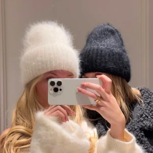 Vit mohair mössa  - Mysig vit stickad mössa med ribbad design. Perfekt för kalla vinterdagar och höstpromenader. Den fluffiga texturen ger extra värme och stil. Helt ny 