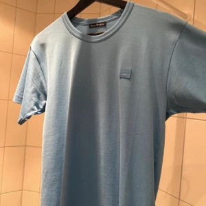 Blå t-shirt från Acne Studios - En jättefin ljusblå t-shirt ifrån Acne Studios, den är i storleken xs, den är som ny endast testad (tags finns kvar) nypris 1400kr