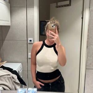 Vit och svart topp GinaTricot  - Snygg ärmlös topp i vitt med svarta kanter. Från GinaTricot, använda 1 gång så i väldigt bra skick. Storlek S.