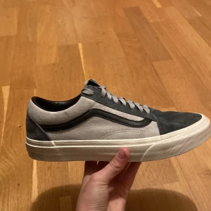 Grå och svarta sneakers från Vans - Snygga Vans sneakers i grått och svart med klassisk design. Skorna har en vit sula och snörning framtill. Perfekta för en avslappnad stil. Skick 9/10 Nypris ca 900