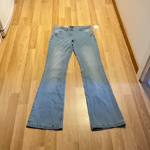 (6) Ljusblåa lågmidjade bootcut jeans, helt nya med lappar kvar. Midjemått rakt över: 35, innerbenslängd: 81 cm. Stretchiga!🩵