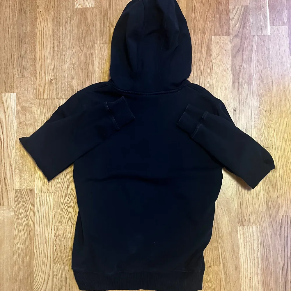 Säljer en snygg HUGO hoodie i svart med röd logga. Använd men i mycket bra skick, utan några skador eller fläckar. Ordinarie pris 1295 kr, säljs på grund av att storleken är för liten för mig.. Hoodies.