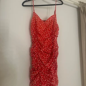 Röd klänning - Min favorit klänning som sitter så fint på. Röd klänning med vita blommor, ”resår/skrynklig” på sidorna för att få en figur. Stl.s/m  