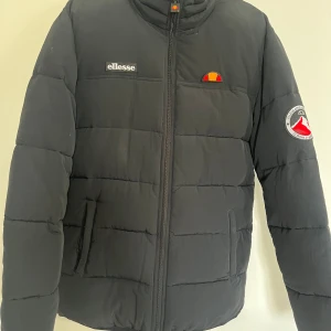 Svart pufferjacka från Ellesse - Säljer en svart pufferjacka från Ellesse i storlek S. Den har ett broderat Ellesse-märke på bröstet. Oanvänd bara provad på. Och materialet är riktigt tjockt o varmt. Perfekt för vintern!