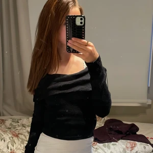 Svart ribbad offshoulder-tröja - Säljer en snygg svart ribbad offshoulder-tröja som är perfekt för både vardag och fest. Tröjan har långa ärmar och en tight passform som framhäver figuren. Den är superbekväm och stilren, perfekt att matcha med både jeans och kjol!