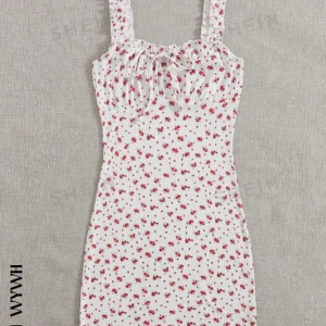 Vit blommig klänning - Säljer en superfin vit klänning med röda blommor. Den har en söt knytning framtill och volangdetaljer vid axelbanden. Perfekt för sommardagar eller en mysig vårpicknick. Klänningen är i nyskick och har en normal passform. Nypris 100kr❤️