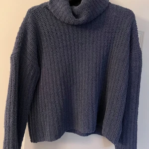 Mörkblå stickad polotröja - Säljer en mysig mörkblå stickad polotröja i storlek L men passar som oversize för mig som oftast bär storlek S 💕 Perfekt för kyliga dagar med den höga kragen och långa ärmar. Tröjan har en ribbad struktur och är otroligt varmt och mysig. 