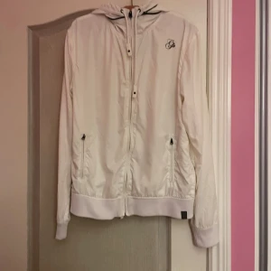 Vit vindjacka  - Jättefin vit tunn vindjacka som också går att ha som kofta från G Star Raw. I nyskick och säljer då den inte riktigt är min stil. Storlek M och unisex!