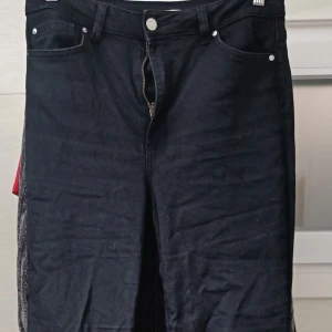 Svarta bootcut jeans - Snygga svarta bootcut jeans med dragkedja och knapp framtill. Perfekta för en stilren look. De har en klassisk design med fem fickor och är tillverkade i ett bekvämt material. Säljer dessa svarta utsvängda jeans med hög midja. Köpta på Cubus för inte så längesen.  Dock är där en fläck på höger knä, se bilder för skick.  Modell: curve bootcut Strl L/32, se bild.