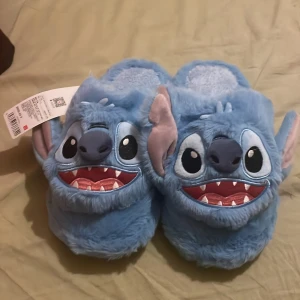Stitch-tofflor - Mysiga blå tofflor med en Stitch-design. Helt nya och oanvända. Storlek 38-39.