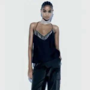 Fest topp zara - Aldrig använd bara testad,ifrån Zara💕Elegant svart linne i satinmaterial med tunna axelband och glittriga detaljer längs halsringningen. Toppen har en öppen rygg med korsade band