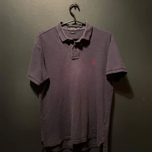 Mörkblå pikétröja från Ralph Lauren - Säljer en stilren mörkblå pikétröja från Ralph Lauren med klassisk krage och knappslå. Tröjan är i storlek M men sitter mer som S. Tröjan har en broderad logotyp i rött på bröstet och är i slim fit. Perfekt för en avslappnad men ändå uppklädd look .