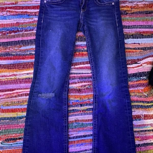 Blå bootcut jeans - Super fina lågmidjade blå bootcut jeans ! Tyvärr har de fått en liten ”spricka” där vid bakfickorna, men det borde vara väldigt lätt att sy in om ni har en symaskin!💕 byxorna är i storlek 146/152💕
