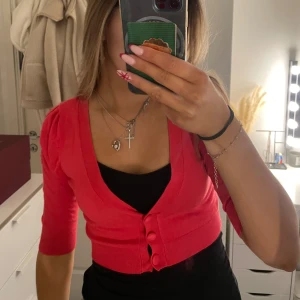 Rosa kofta med knappar - Säljer en söt rosa kofta med knappar framtill. Koftan har en v-ringad design och trekvartsärmar som passar bra till både vardag och festliga tillfällen.