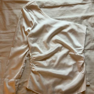 One shoulder topp BikBok - Snygg one shoulder topp i satin från Bikbok! Storlek S. Har en liten slits på armen. Endast använd 1 gång! Perfekt till fest och nyår🎉