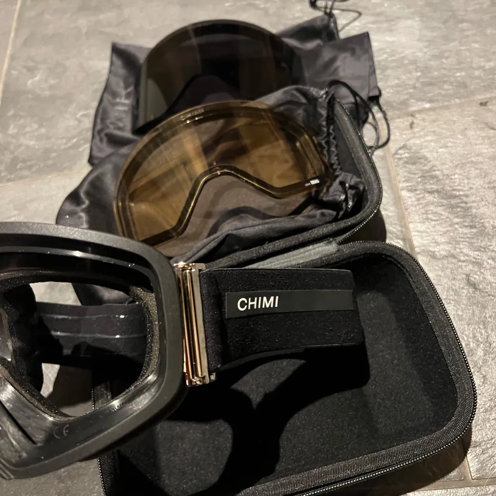 Snygga och funktionella skidglasögon från CHIMI i modellen O2. De har en svart design med Zeiss-linser för optimal sikt. Justerbart band med CHIMI-logga och kommer med ett praktiskt fodral och extra lins. Notera att dessa är den ”dyrare” modellen och där med priset.. Asusteet.