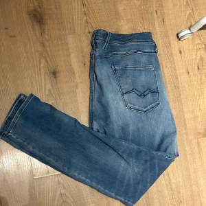 Blå jeans med slitningar - Säljer ett par snygga blå jeans med coola slitningar från replay! pris kan diskuteras vid snabb affär!