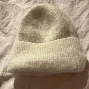 Stickad beige mössa - Säljer denna super snygga mössan från MQ, använd förra vintern och säljs för bara 90 kr original pris ungefär 350 kr!