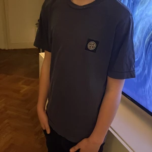 Stone Island T-shirt  - Säljer en stone Island t-shirt i bra skick. Den har en liten logga på bröstet och är kortärmad. Perfekt för vardagsbruk eller en avslappnad dag ute. Passar bra till jeans eller shorts! En defekt lappen där back är sönder 