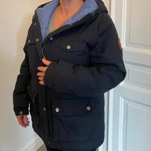 Fjällräven vinterjacka - Fint skick, inga hål eller slitage. Gammal model så hittar inte vad den heter.  Modellen är unisex så passar bådde herr och dam Storlek:S  färg mörkblå nästan svart med ljusblå innersida.