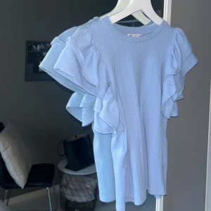 Blå volangtopp zara - Säljer denna blå volangtopp från zara. Den är i storlek S och är i bra skick. 